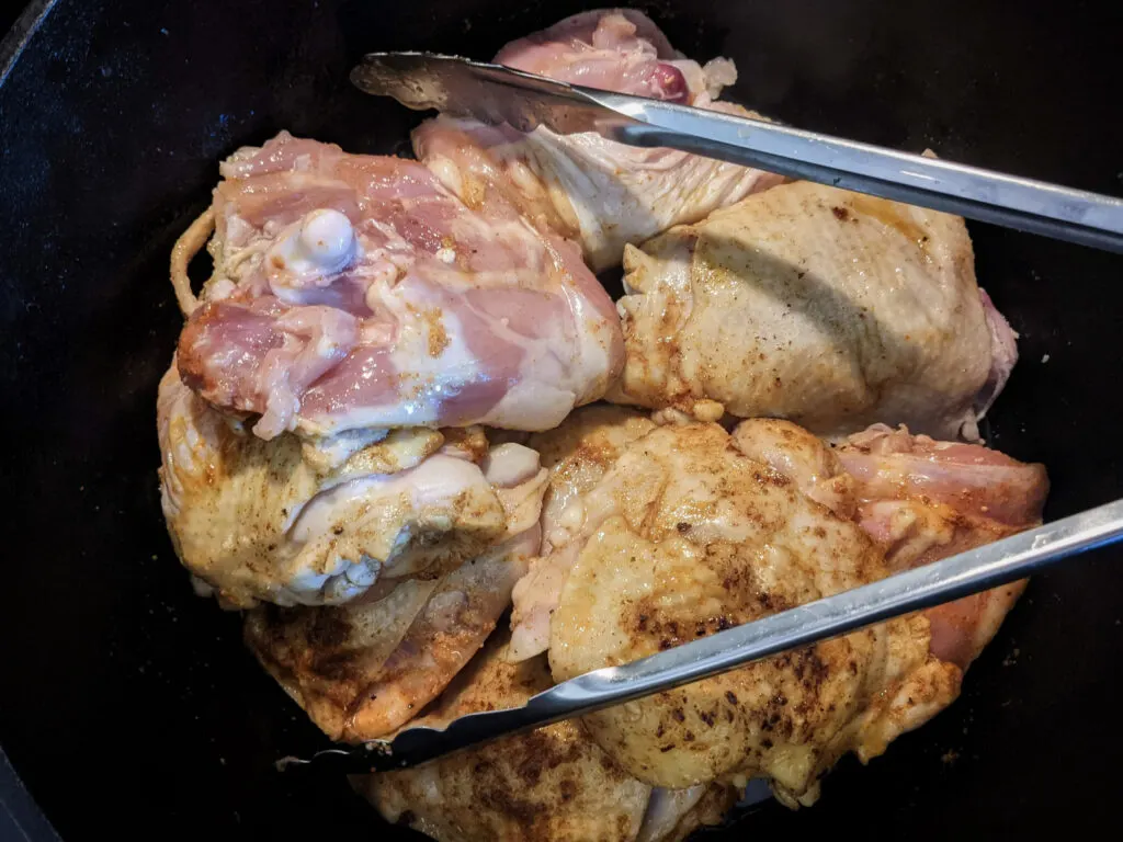 Chicken frying in a Dutch oven.