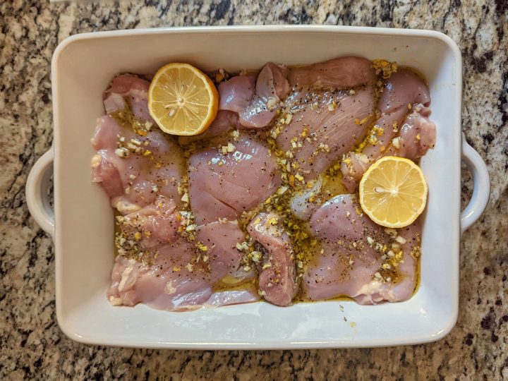 Nestle the halved lemons into the baking dish with the chicken.