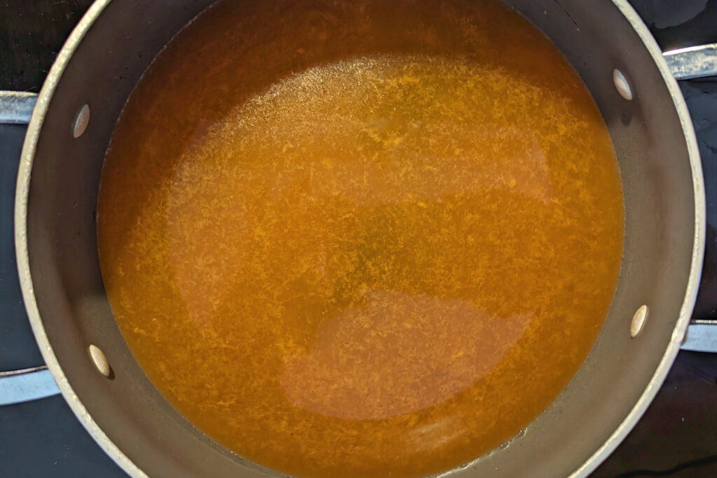 Kimchi jjigae broth in a stockpot.