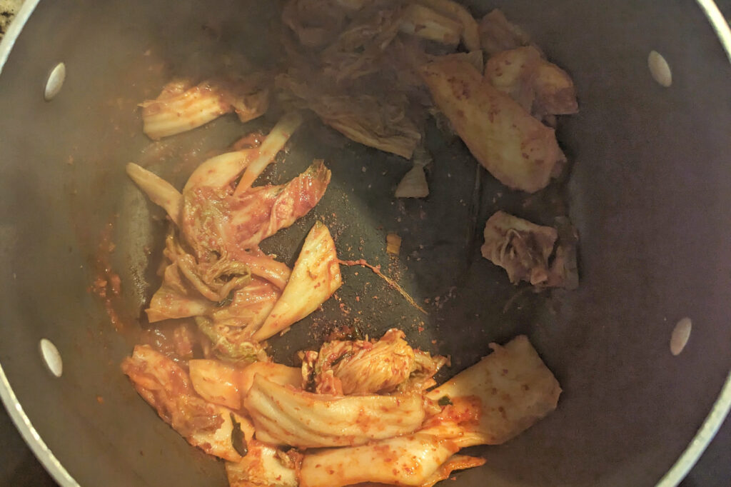 Kimchi sautéing in a pot.