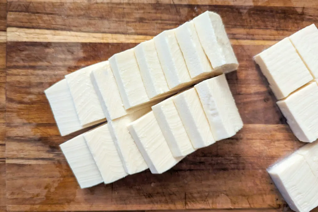 Slices of tofu on a cutting board.