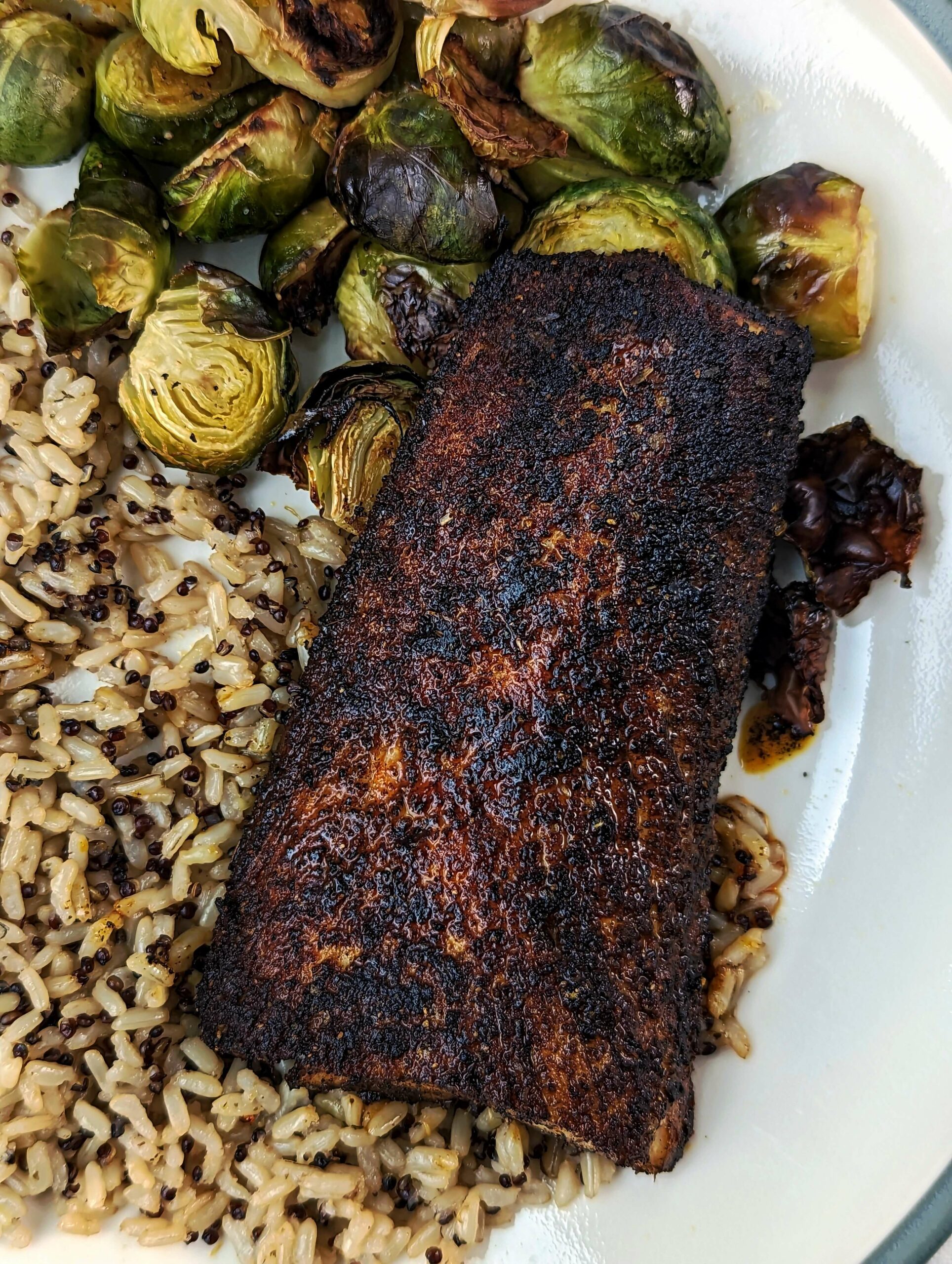 A mahi mahi fillet served with brussel sprouts and rice pilaf. 