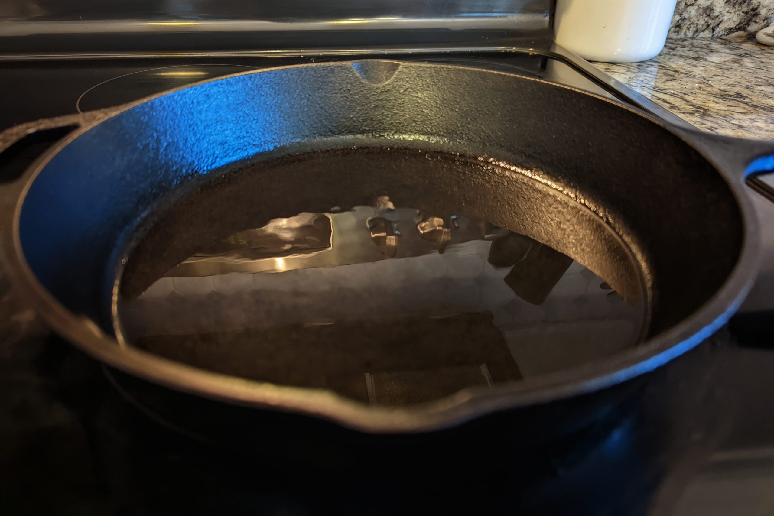 Mahi mahi fillets seasoned with blackened seasoning searing in a cast iron skillet. 