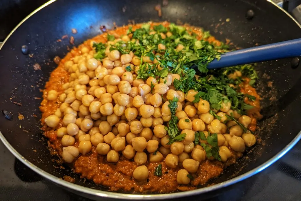 Cilantro and chickpeas added to the plan with the masala.