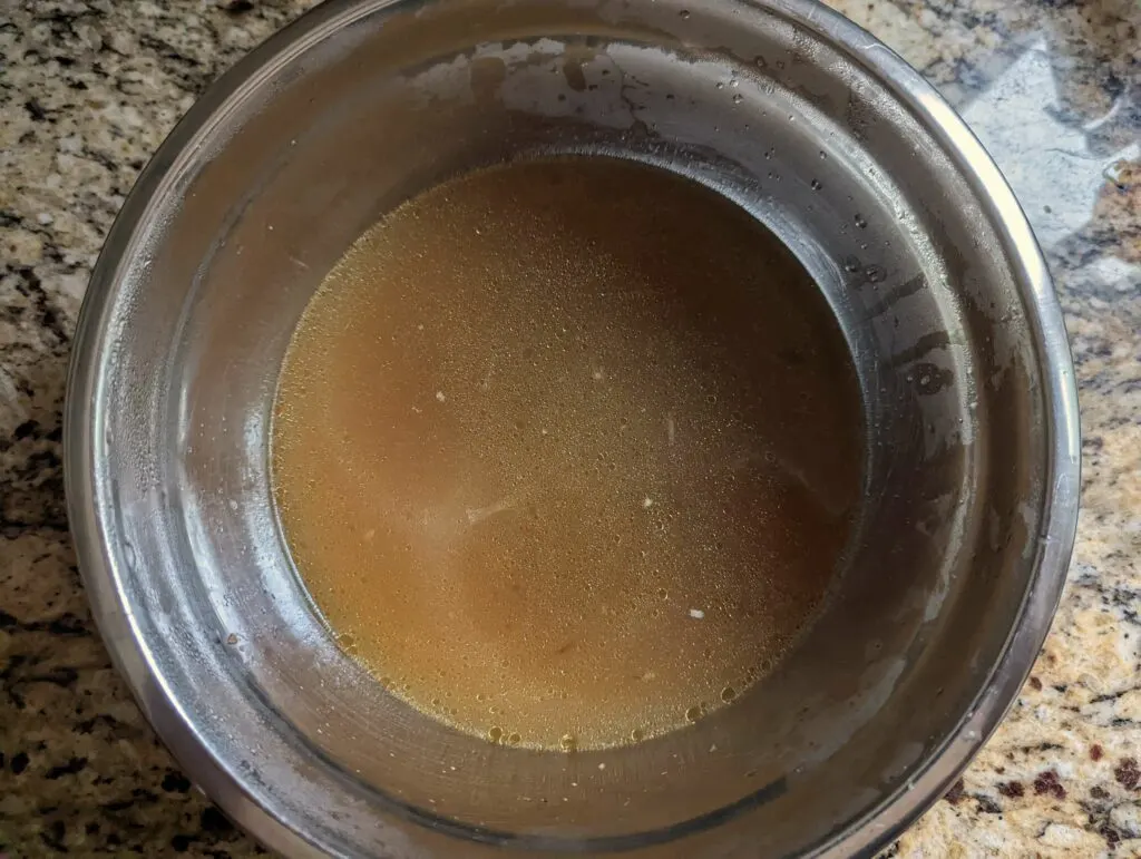 Chicken stock in a mixing bowel after being strained.