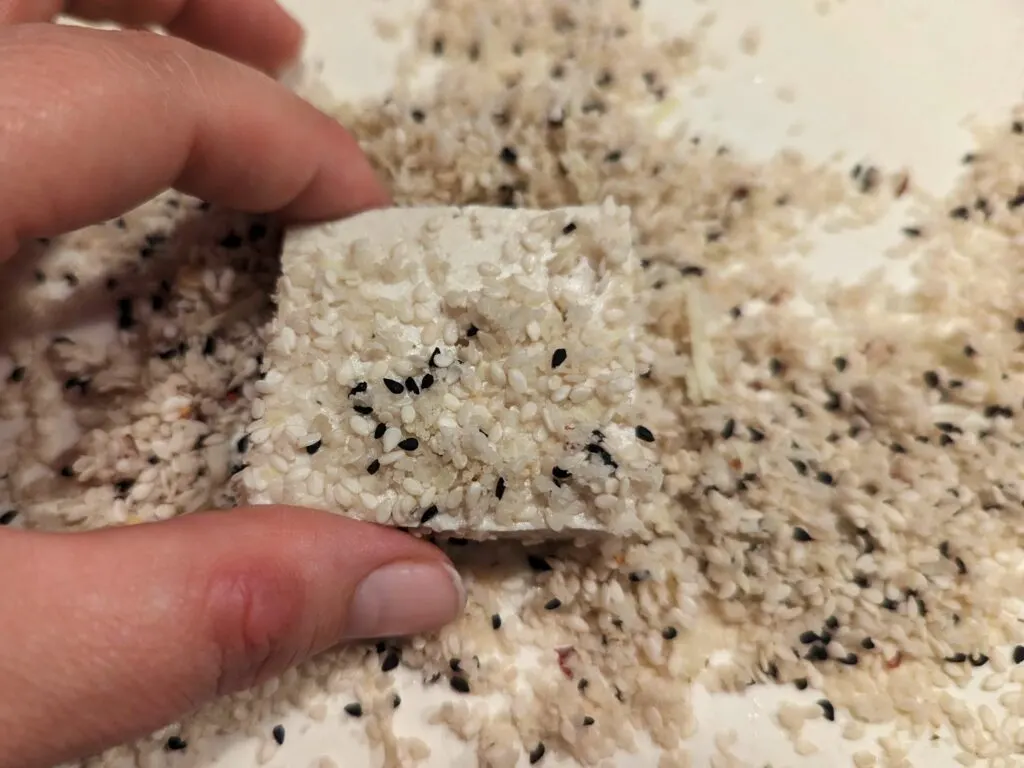 Coat the tofu in the sesame seed mixture.