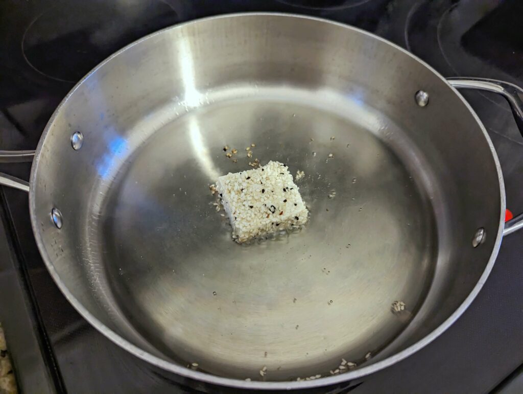 Test frying one piece of tofu to gauge the heat of the oil.