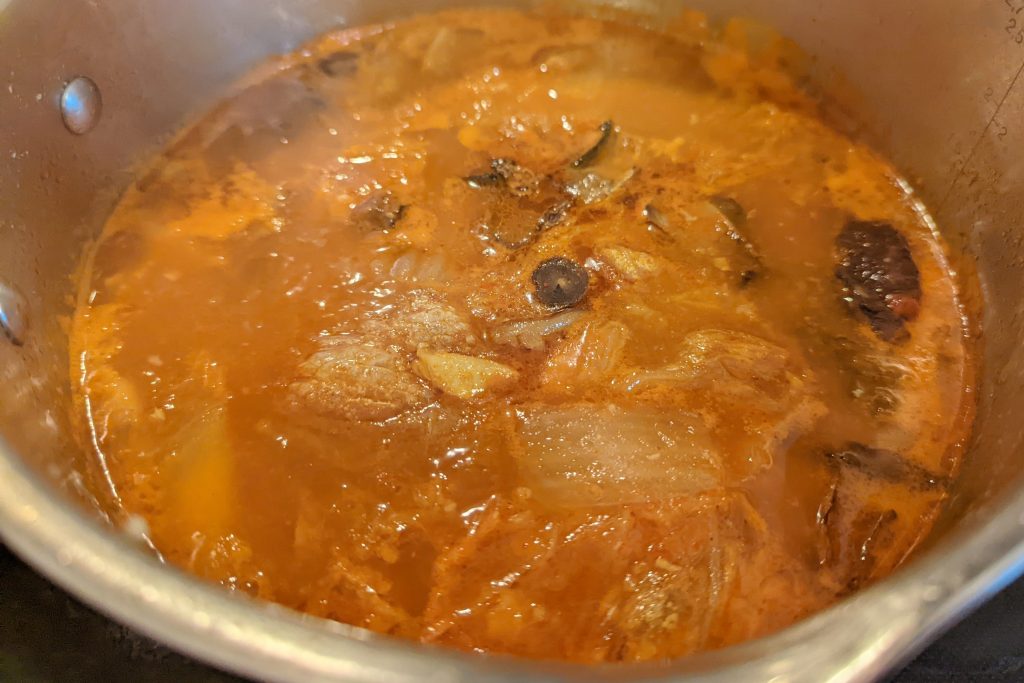 Kimchi and spices are added to broth.