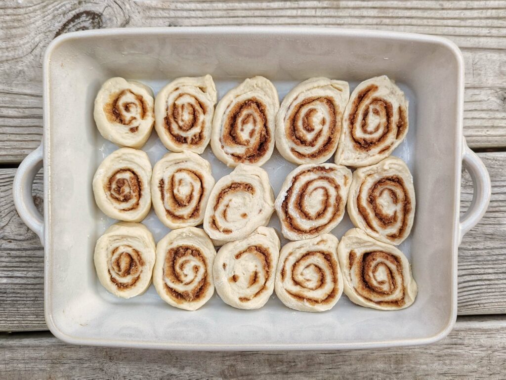 Cinnamon rolls lined into a baking dish.