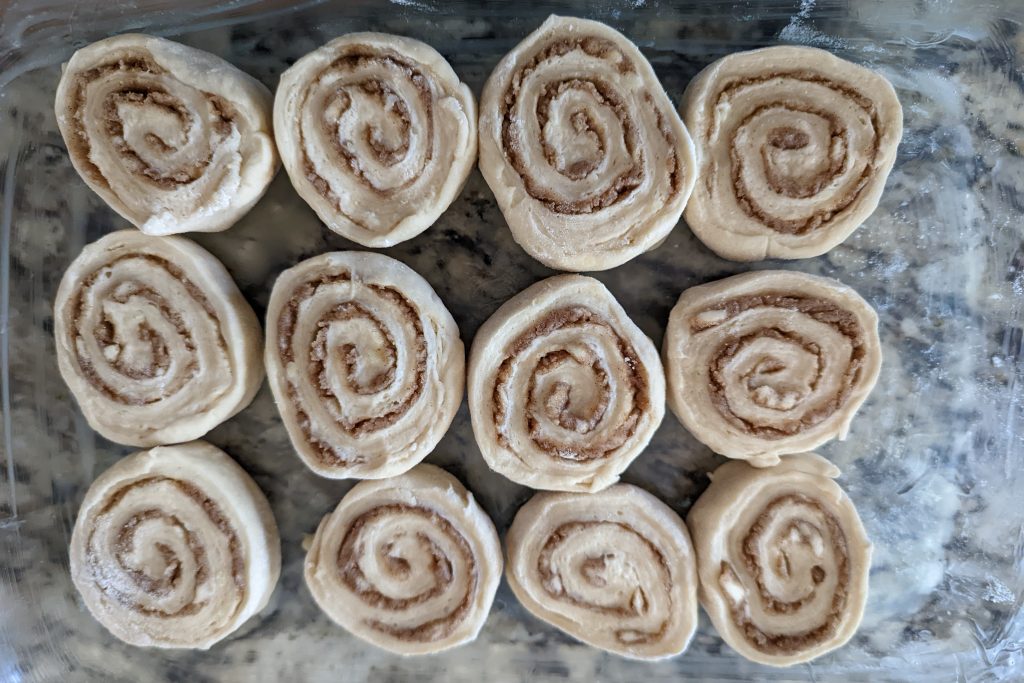 cinnamon rolls lining a baking pan