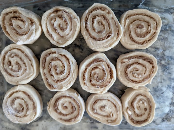 cinnamon rolls lining a baking pan