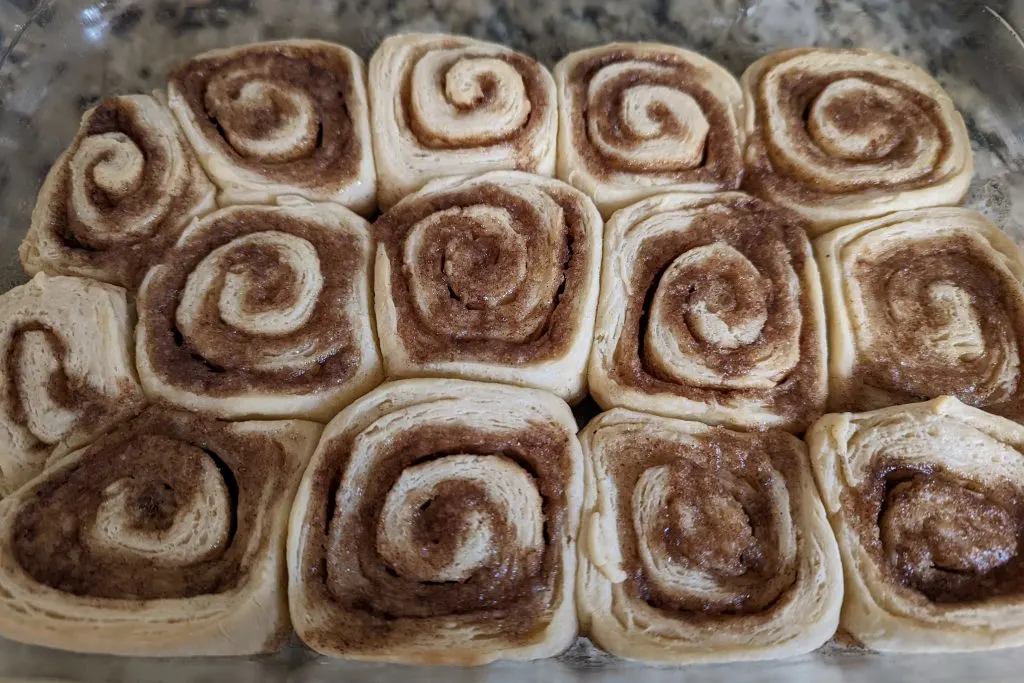 Cinnamon rolls in a baking dish after they have baked.