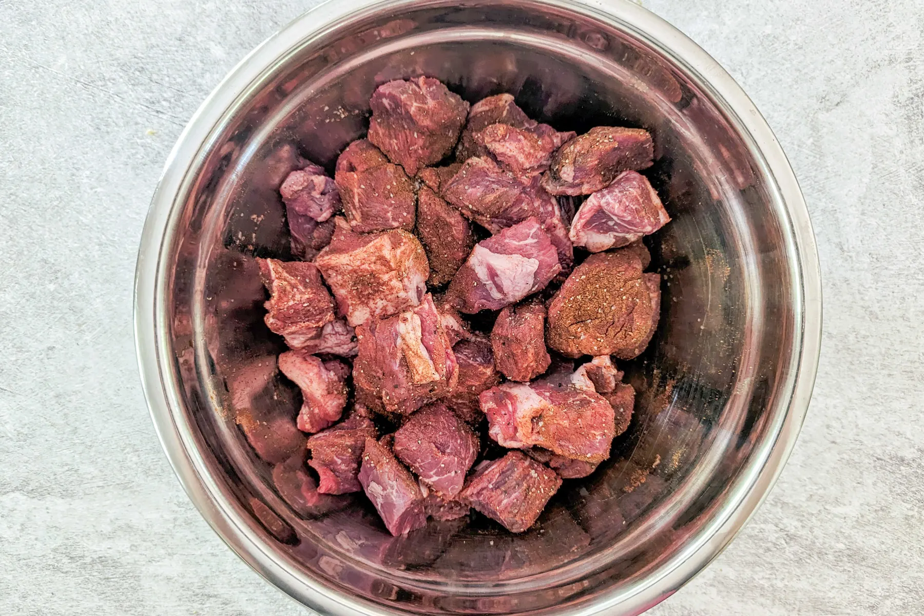 Seasoned beef in a mixing bowl.