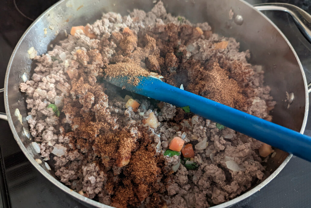 Ground beef and spices cooking in a pan.