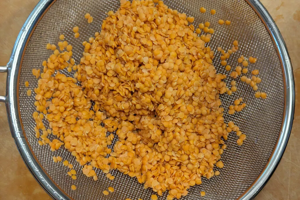 Dal rinsed in a mesh sieve.