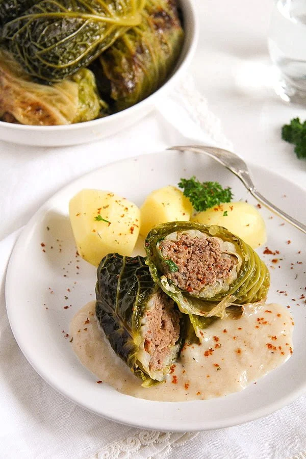Cabbage rolls on a plate with boiled potatoes.