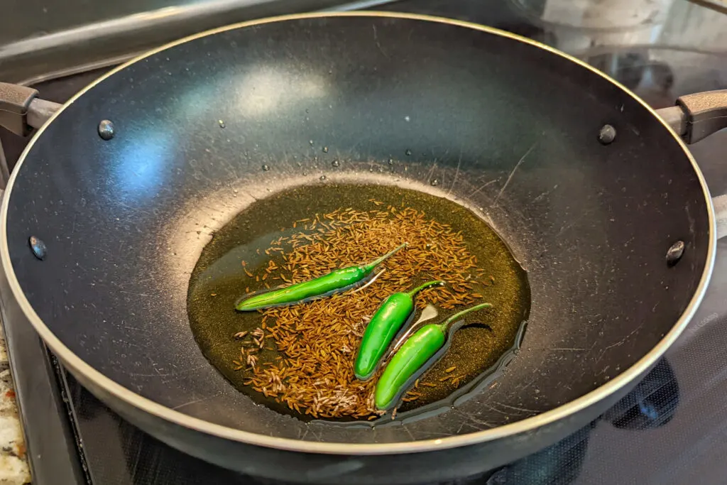 Cumin seeds and chiles toasting in ghee.