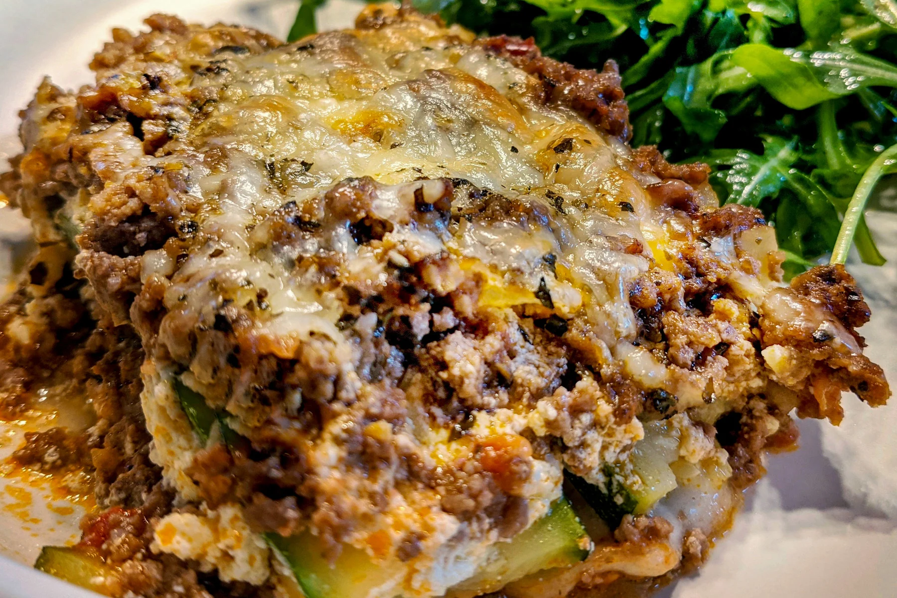 A heaping portion of zucchini lasagna on a plate. 