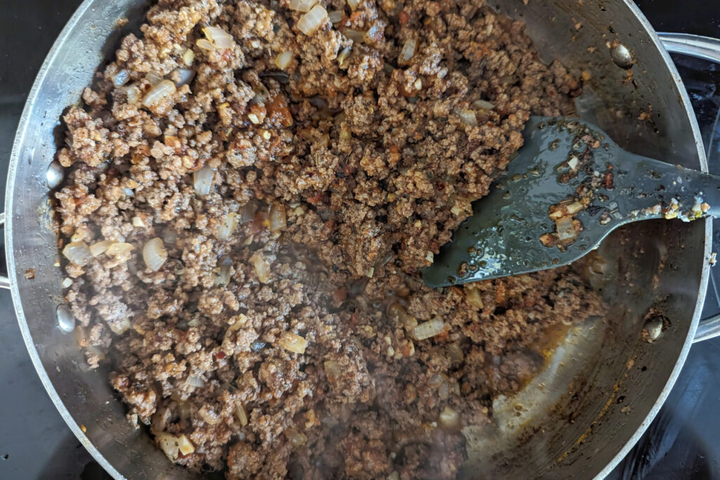 Sauce and seasoning is added to the ground beef mixture.
