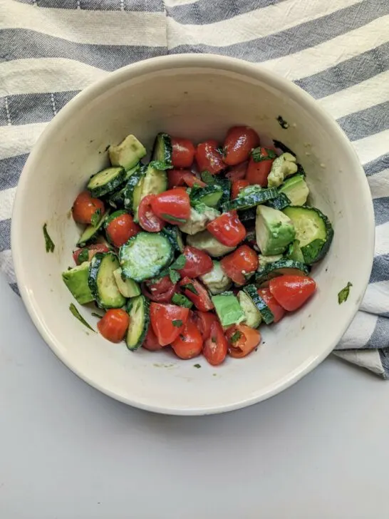 Avocado cucumber tomato salad in a serving bowl.