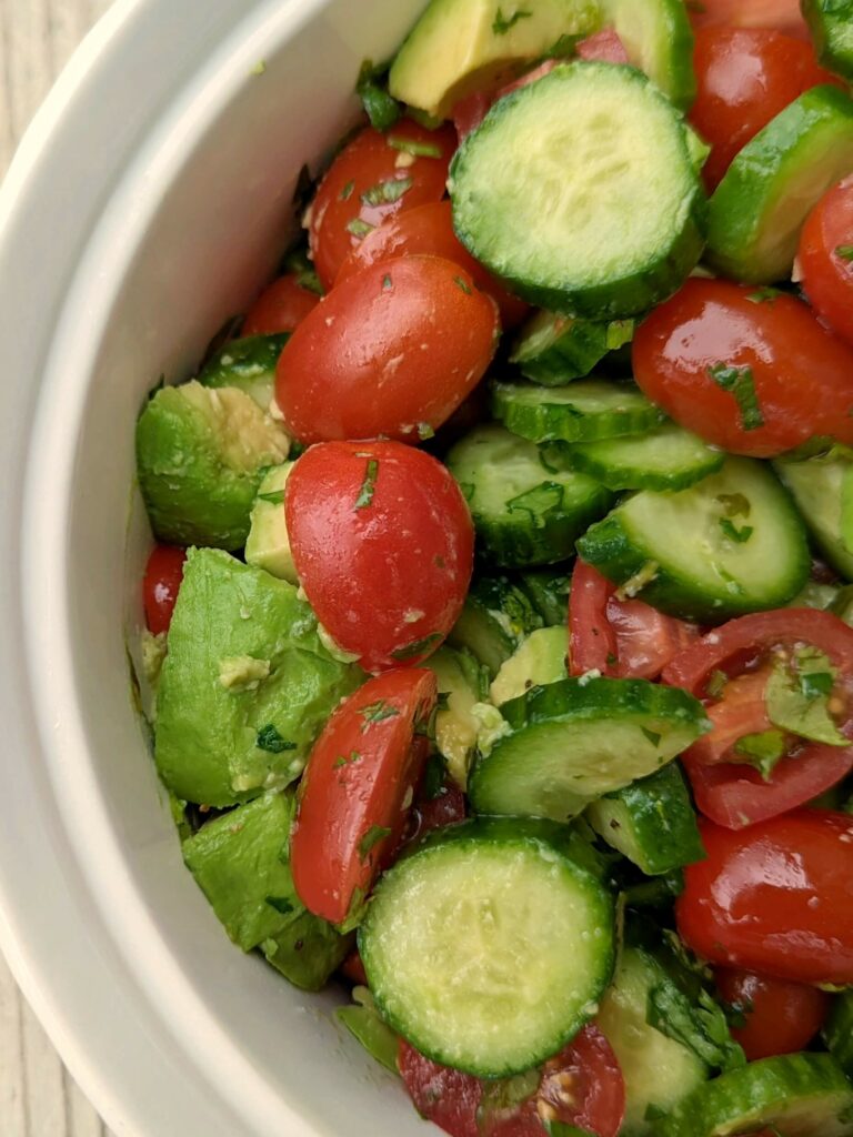 Avocado cucumber tomato salad in a bowl.