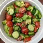 Avocado cucumber tomato salad in a serving bowl.