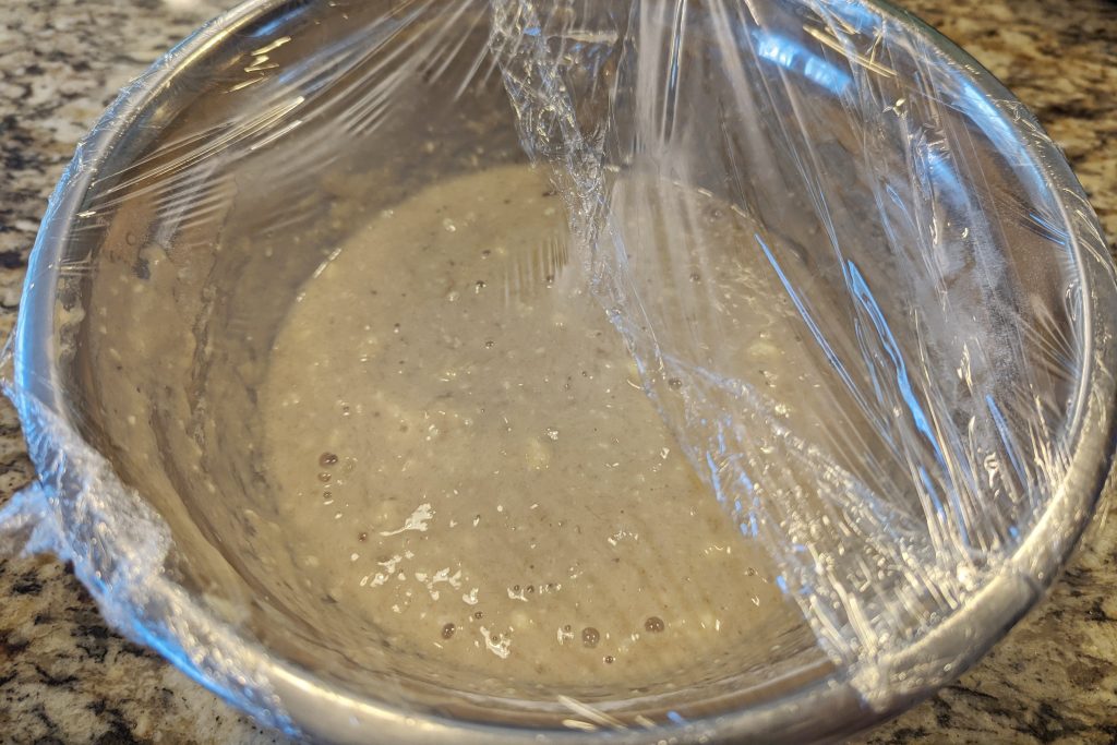 The banana bread mixture covered with plastic.