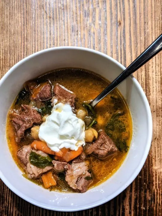 A single serving of beef and chickpea stew topped with yogurt and ready to be served.