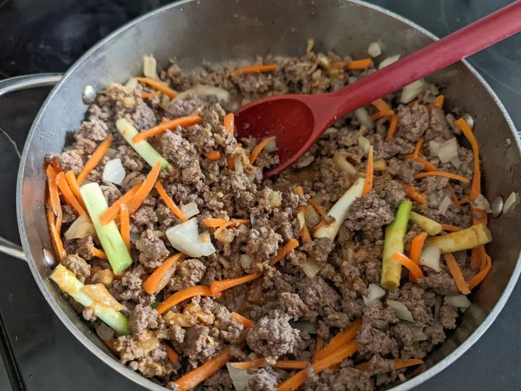 Onion and carrot added to the cooking ground beef.