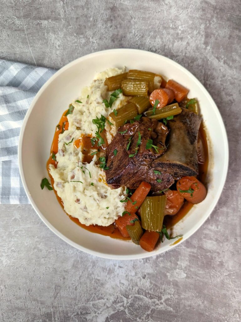 A single serving of braised short ribs over creamy mashed potatoes.
