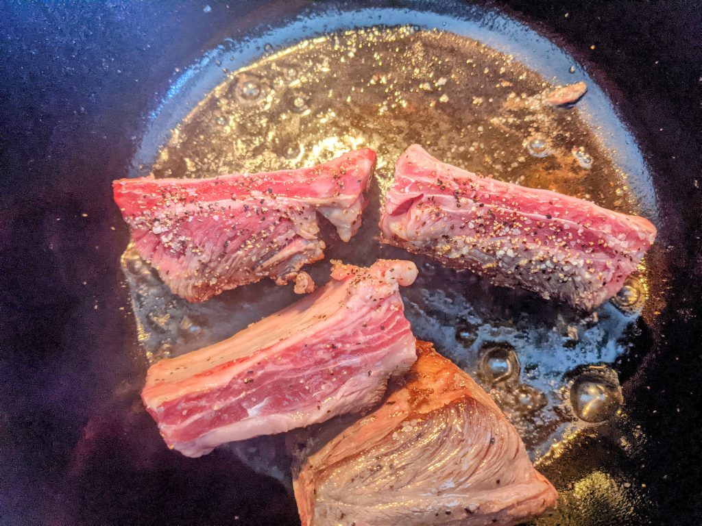 The first step to braising short ribs is to sear them in a pan with oil until all the sides have a nice browning.