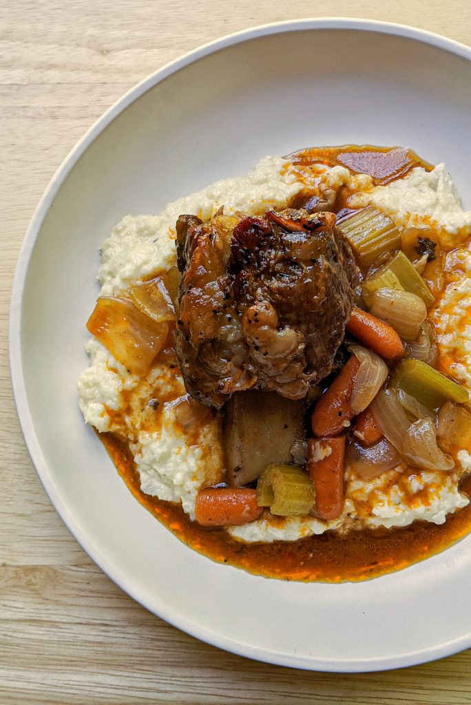 A single serving of braised short ribs over creamy cauliflower rice.