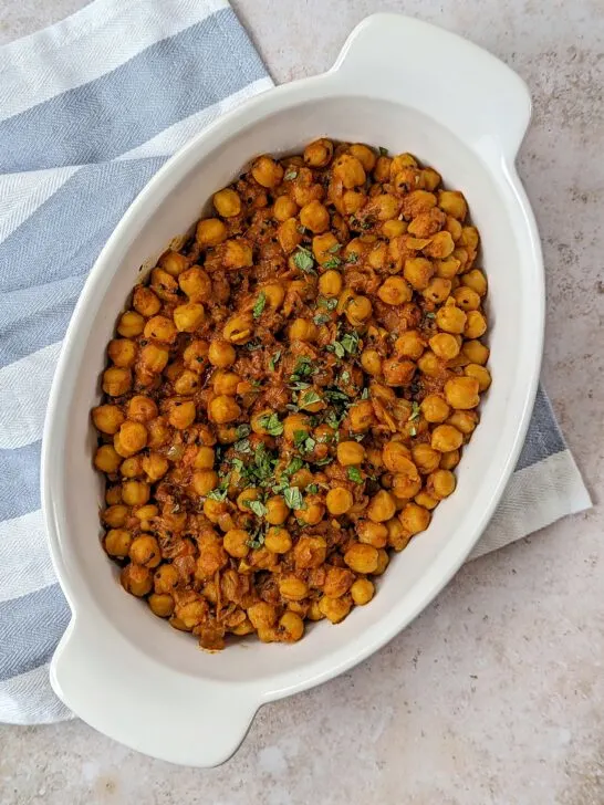 Channa Masala in a serving bowl topped with chopped cilantro.