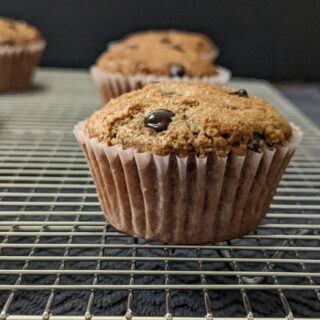 Chocolate protein muffins cooling on a wire rack.