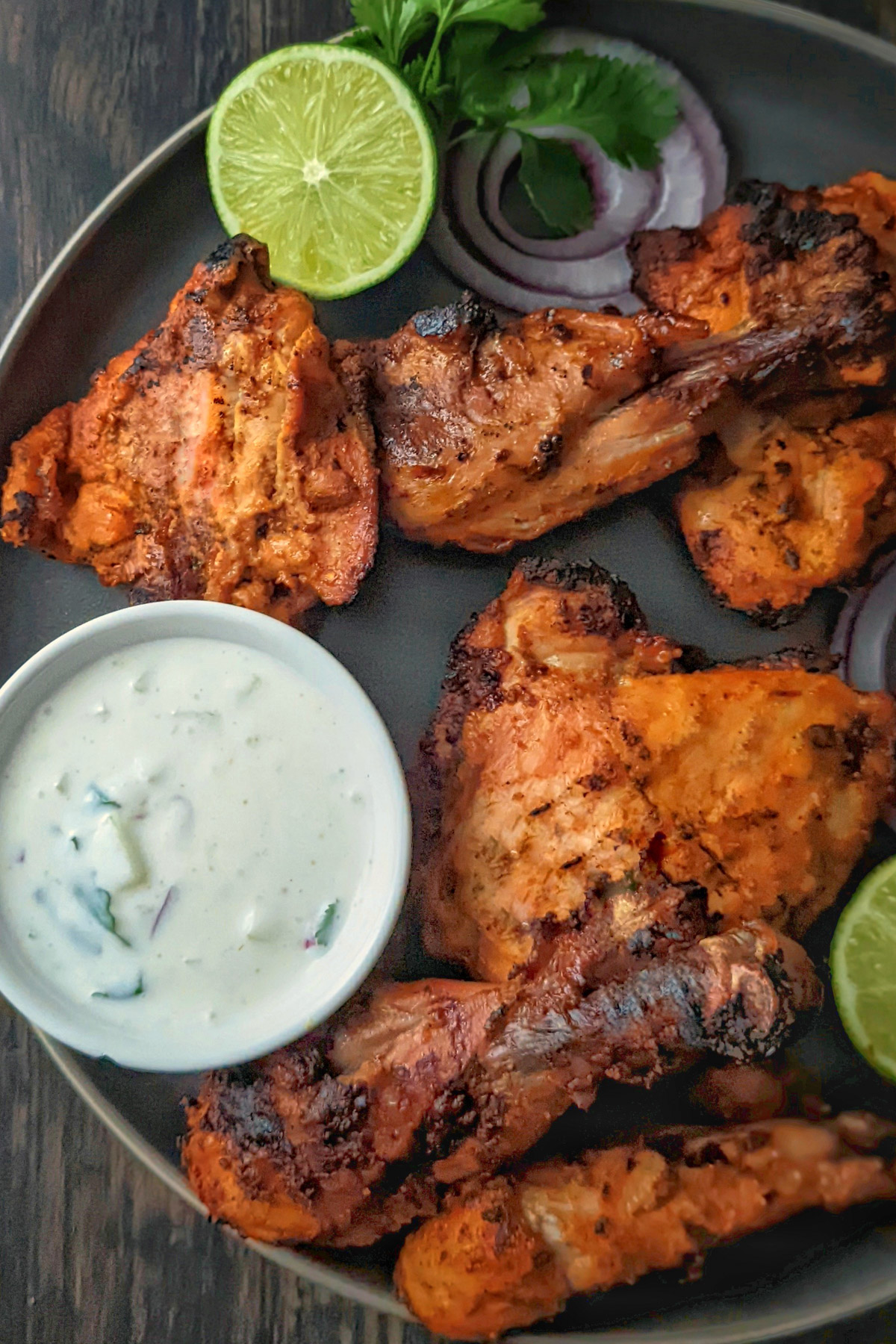 Grilled tandoori chicken on a serving plate.