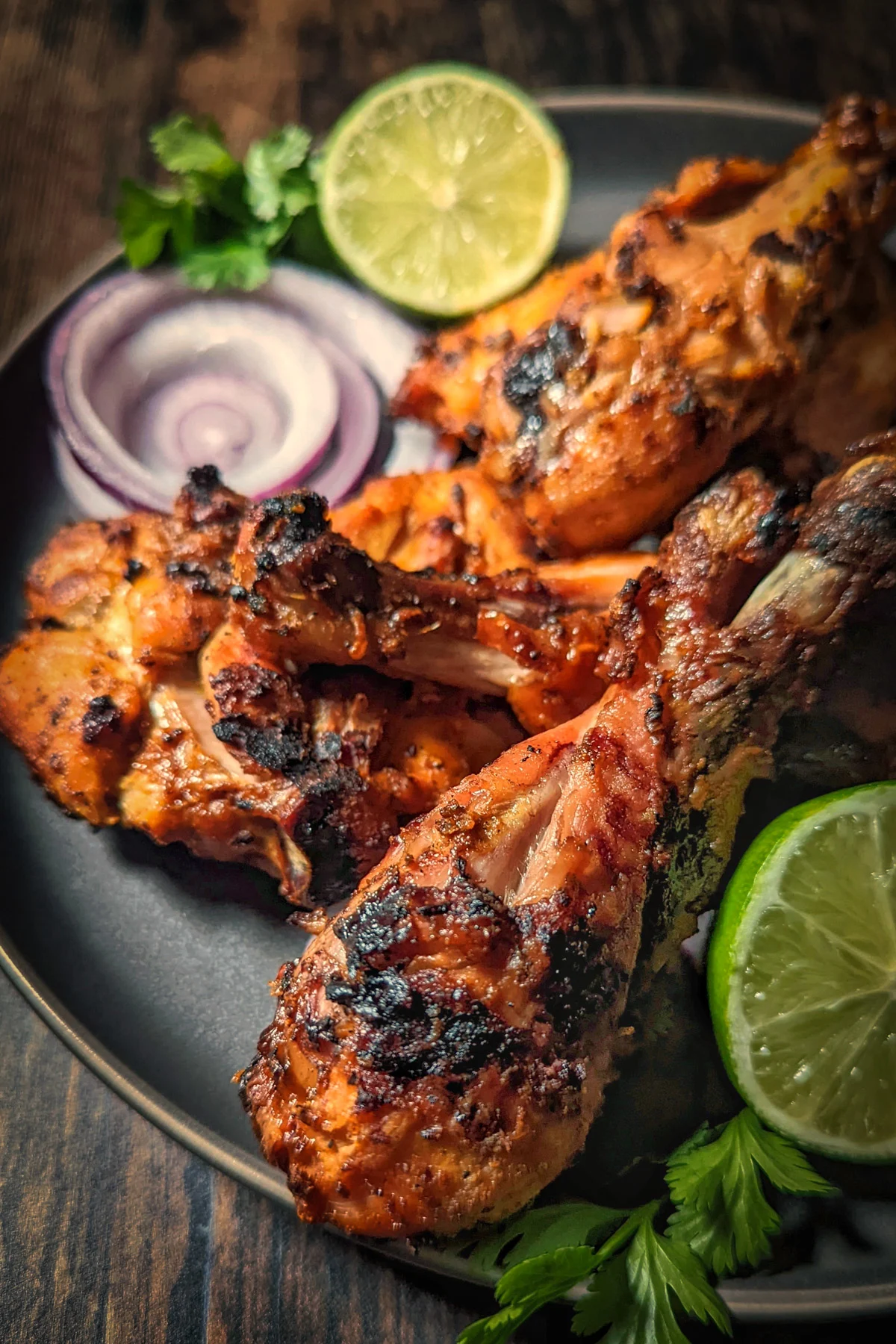 Grilled tandoori chicken on a serving plate.