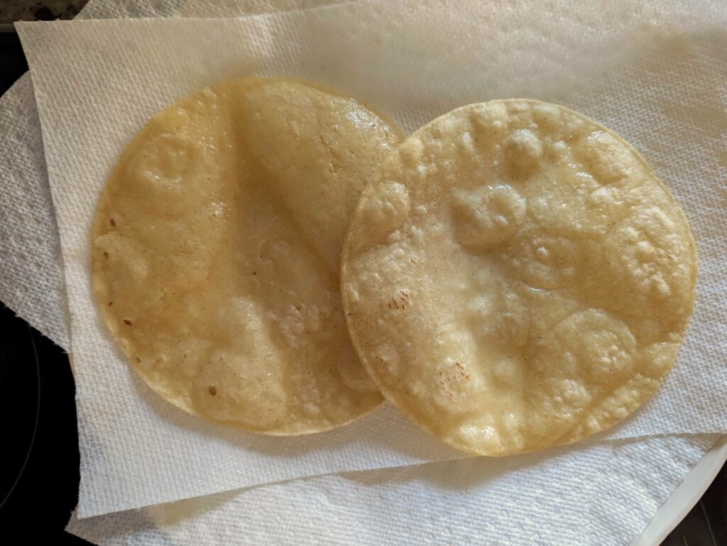 Corn tortillas drying on a paper towel.