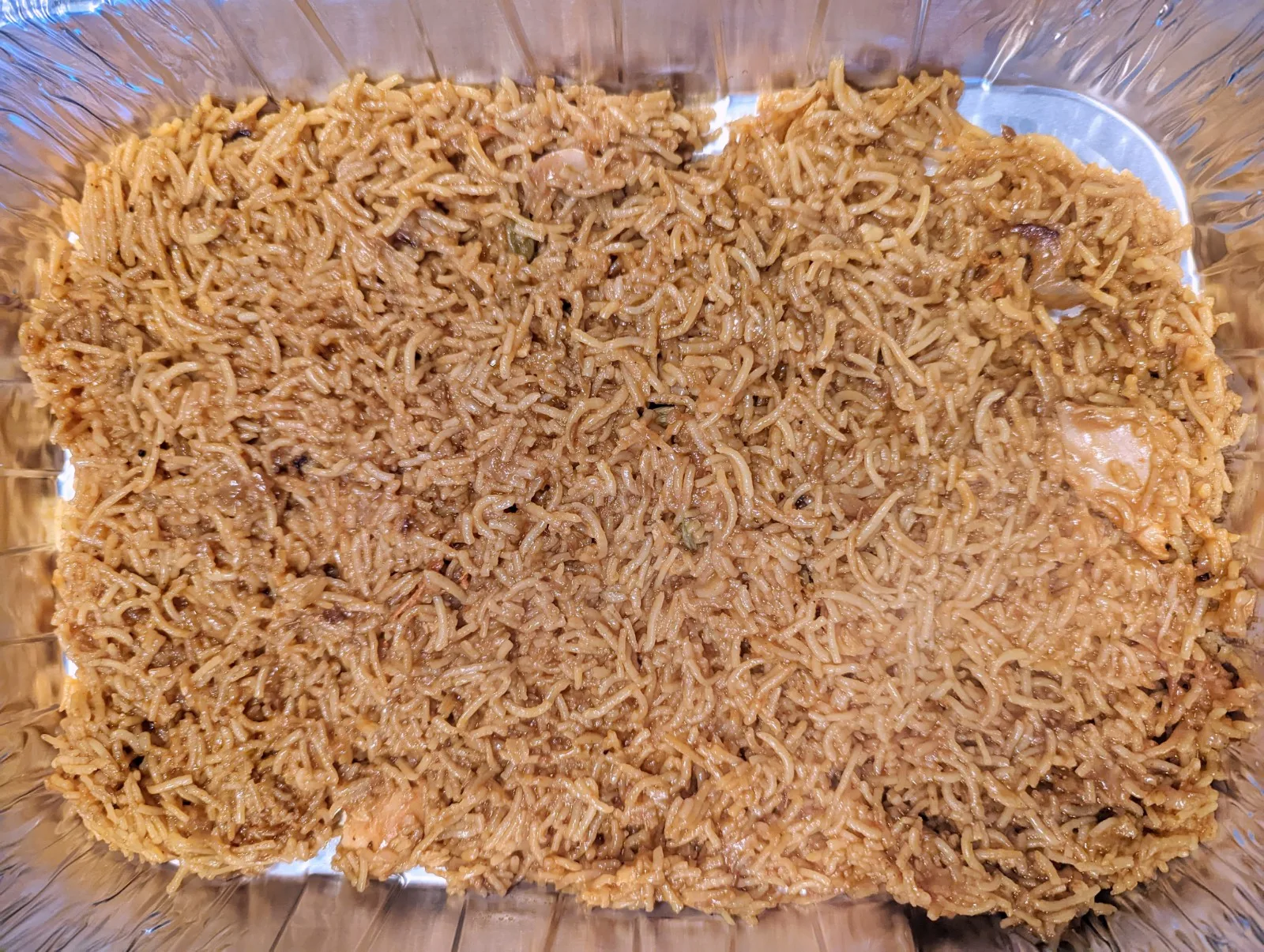 Biryani Rice in the bottom of a serving dish.