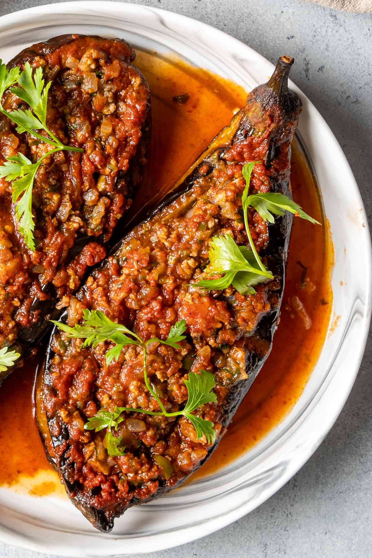 Stuffed eggplant on a plate and garnished with cilantro.