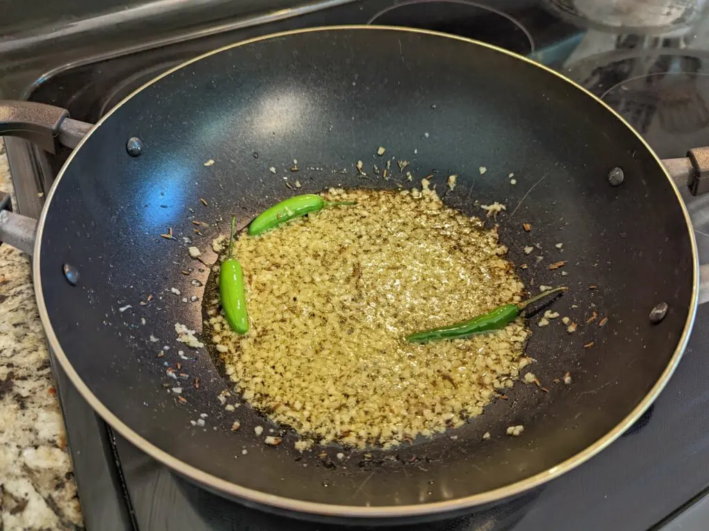 Garlic and ginger added to fry in a pan.