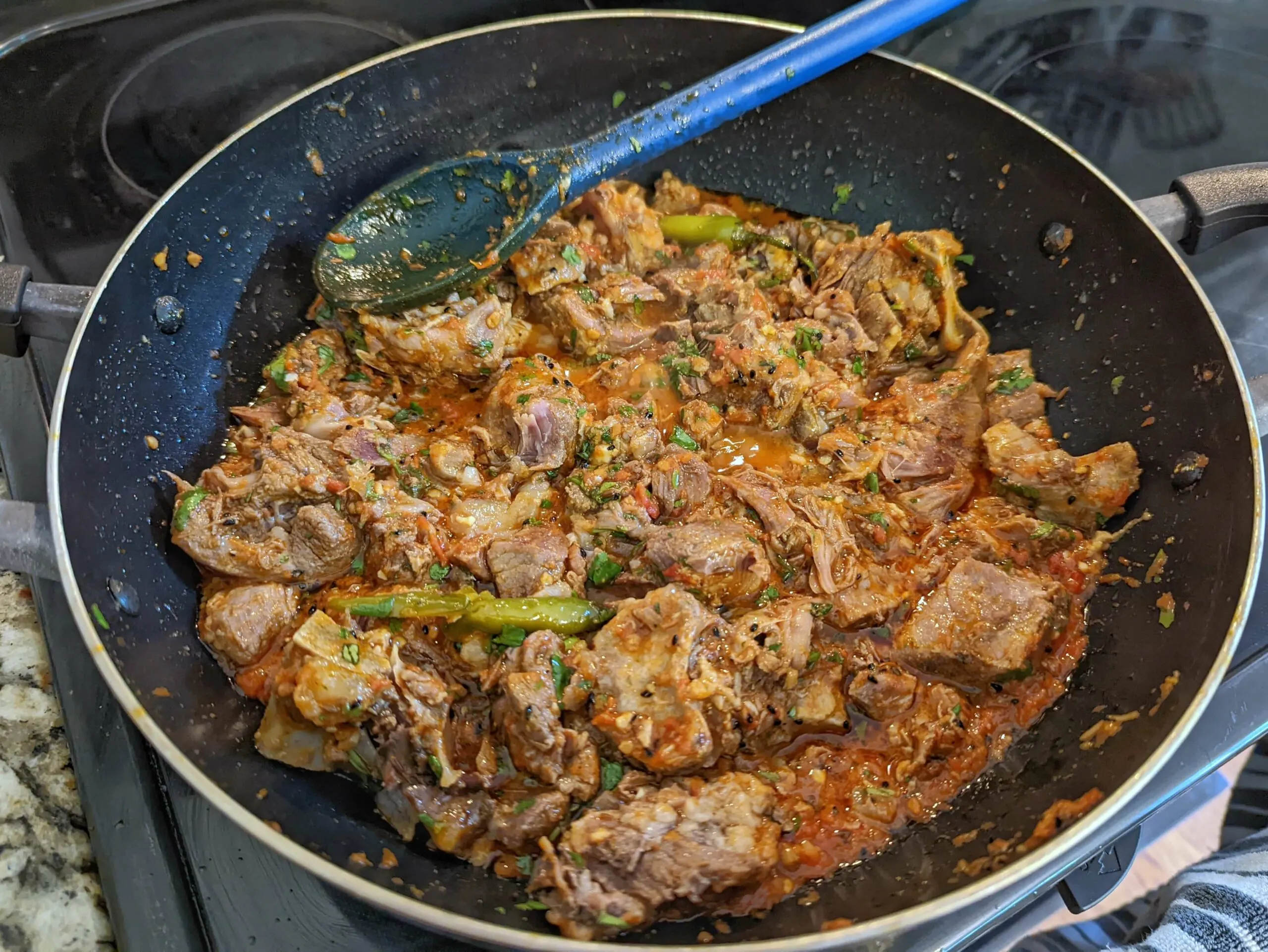 Stir and simmer the karahi gosht to allow the ingredients to incorporate.