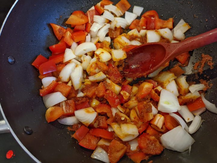 onions and bell peppers added to the oil and curry paste for panang thai curry.