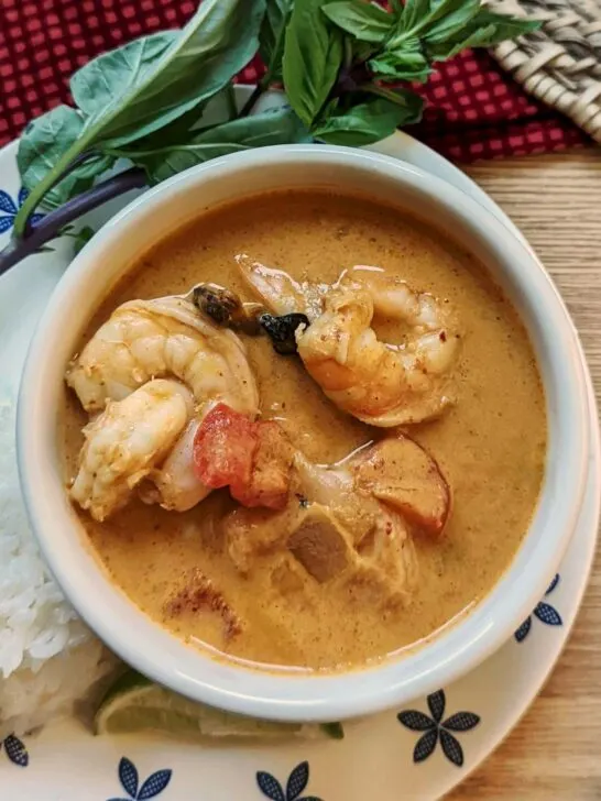 Shrimp panang curry in a bowl with basil.