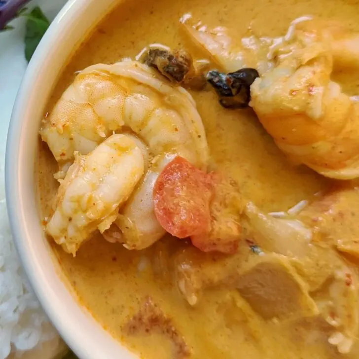 Shrimp panang curry in a bowl with basil.