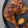 Baked tandoori chicken on a plate with vegetables.