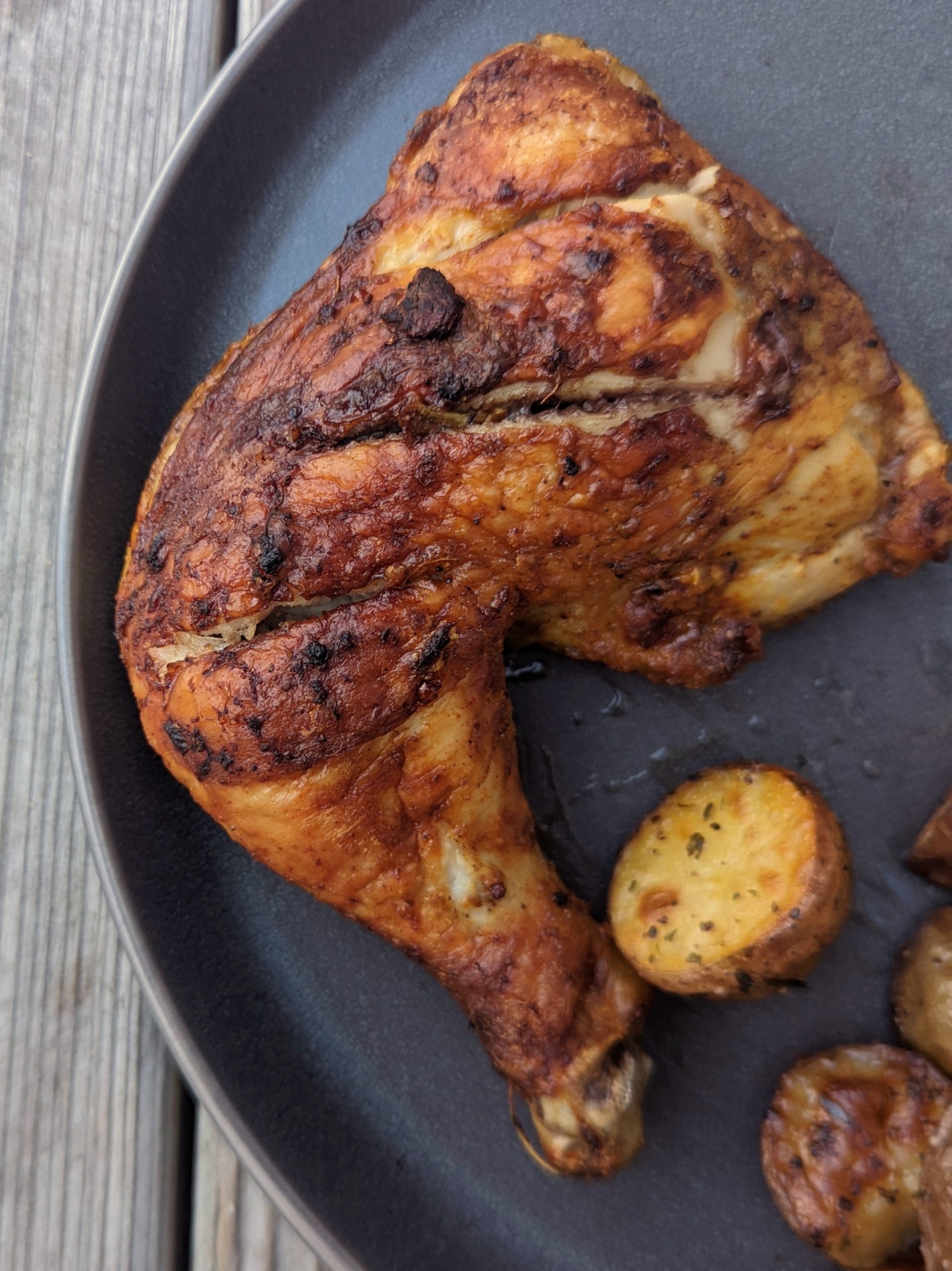 A serving of our baked tandoori chicken recipe served with raita and roasted potatoes.
