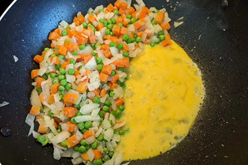 Eggs added to one side of the wok.