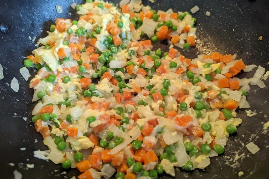 Eggs scrambled into the wok.