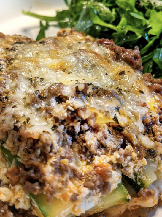 A heaping serving of zucchini lasagna served with an arugula salad.