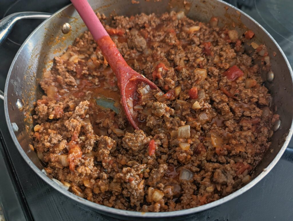 Sauce and seasoning is added to the ground beef mixture.